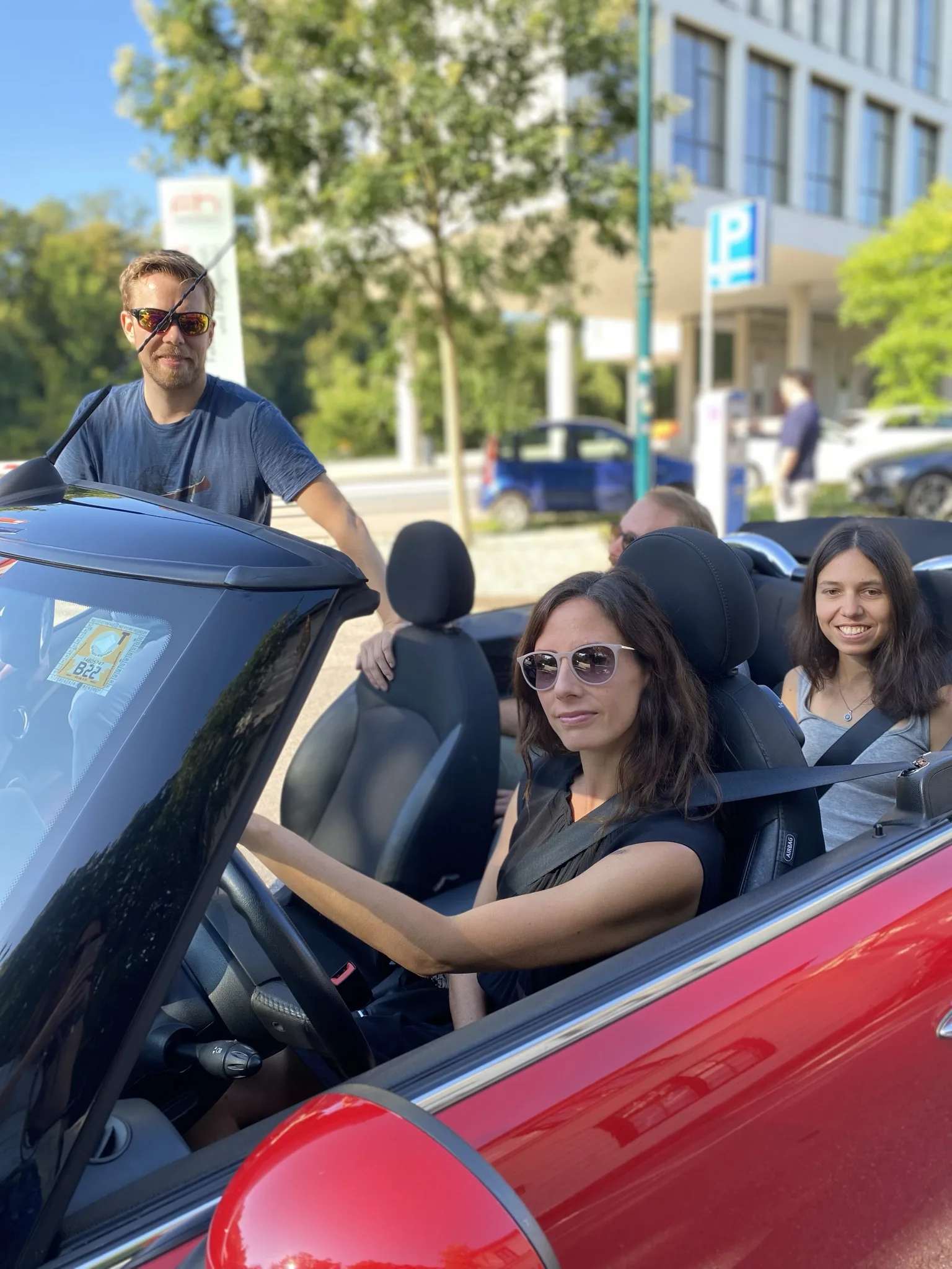 Drei Personen fahren gemeinsam in einem Auto und lachen