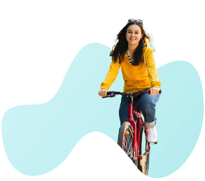 Junge Frau in gelber Jacke auf Fahrrad auf dem Weg zur Arbeit